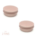 A pair of rose gold reusable metal travel tins for eco friendly shampoo bars and conditioner bars, shown on a clean white background.