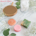 A colorful spa set featuring shampoo and conditioner bars, arranged on a marble surface with fresh white flowers.