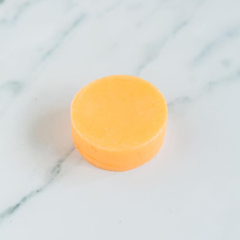 Refreshing citrus conditioner bar for effortless detangling and eco-friendly hair hydration.