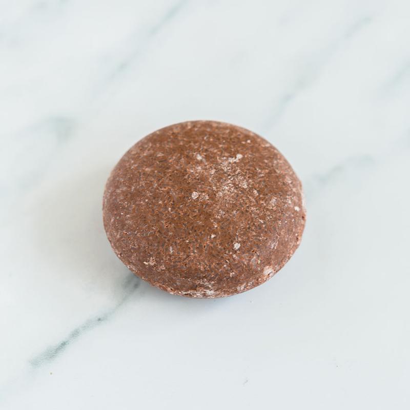 Handmade Argan Oil shampoo bar on a marble surface, natural ingredients for healthy hair.